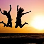 new year background, sunset, beach, silhouettes, jump, jumping, youth, active, happy, pair, girls, young women, people, joy, nature, freedom, seaside, dusk